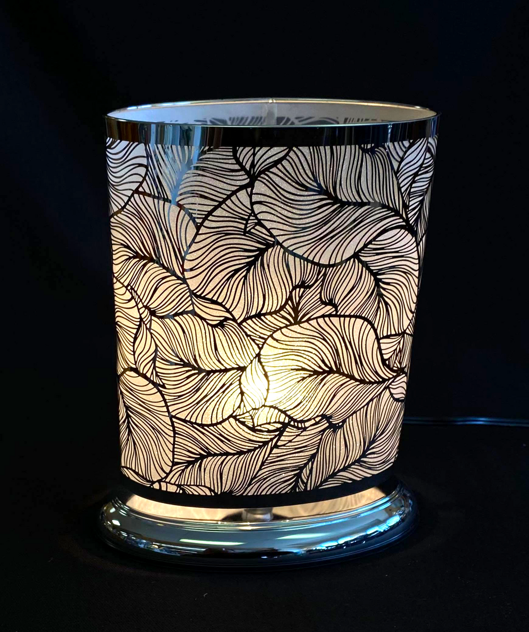 silver oval touch lamp with leaf designs all around 